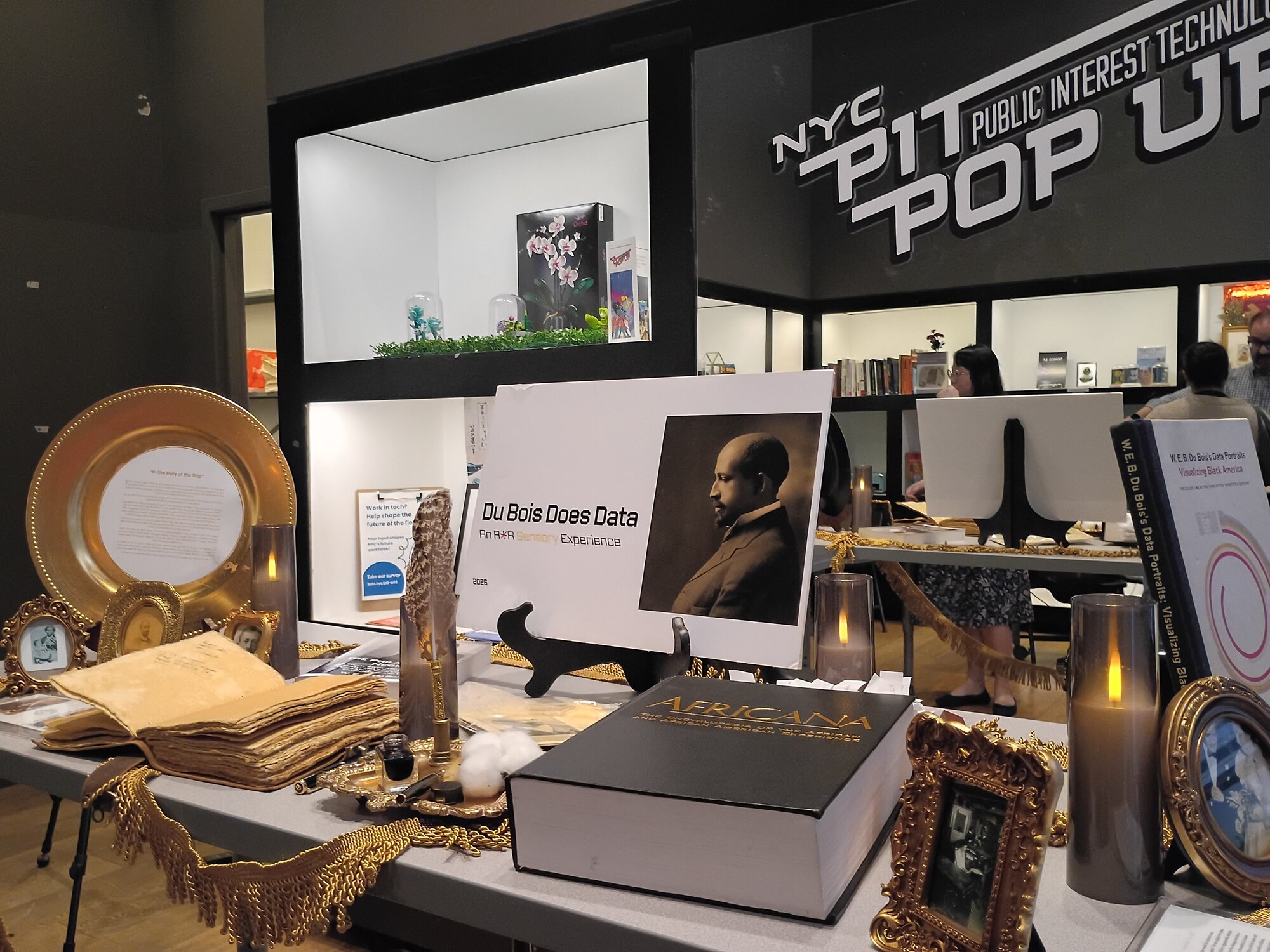 The DDD altar table with Africana book, gold frames, and installation signage